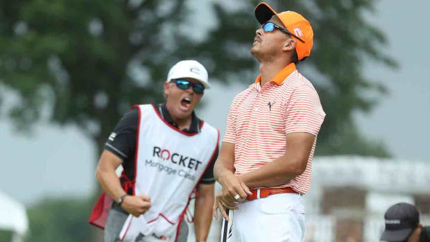 Rickie Fowler, right, and his caddie Ricky Romano react after making birdie on the 18th green to win the Rocket Mortgage Classic in a playoff against Adam Hadwin and Collin Morikawa at Detroit Golf Club on Sunday, July 2, 2023.