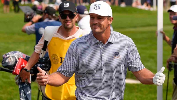 Bryson DeChambeau greets fans on the sixth hole during the final round of the 2023 PGA Championship at Oak Hill Country Club.