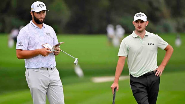 Jon Rahm and Patrick Cantlay wait to putt on the second green during the first round of the 2022 Players Championship in Ponte Vedra Beach, Fla.