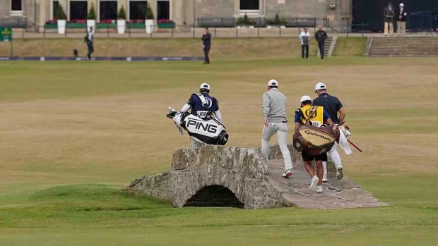 Viktor Hovland, Rory McIlroy and their caddies walk across the Swilcan Bridge at the 2022 British Open.