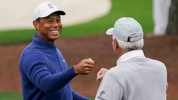 Tiger Woods gives Fred Couples a fist bump during a 2023 Masters practice round.