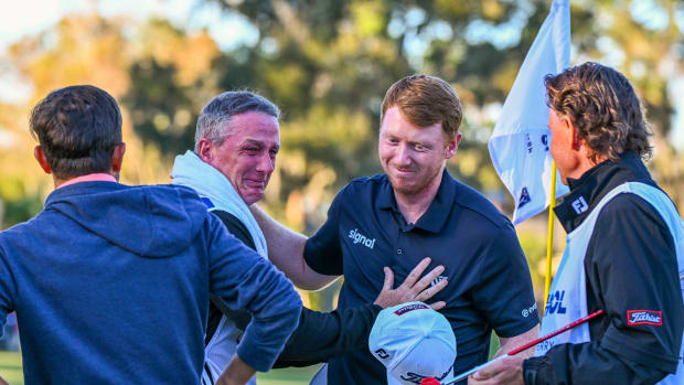Hayden Springer is emotional with his caddie and family friend on the 18th green during the rain-delayed final round of the PGA TOUR Q-School presented by Korn Ferry tournament on the Dye's Valley Golf Course at TPC Sawgrass on December 18, 2023 in Ponte Vedra Beach, Florida. 