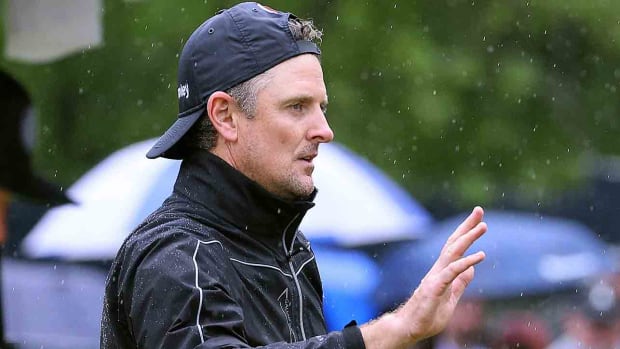 Justin Rose, hat backwards in the rain, waves to the crowd in the third round of the 2023 PGA Championship.
