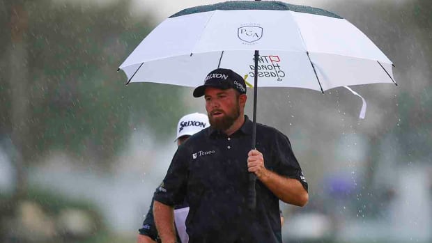 Shane Lowry holds an umbrella on the 18th hole in the final round of the 2022 Honda Classic.