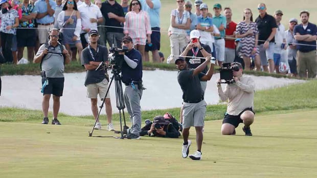 Harold Varner is pictured hitting in front of television cameras at the LIV Golf Washington D.C. event.