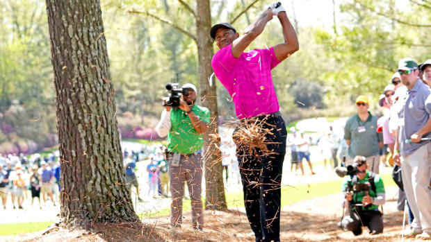 Tiger Woods hits from the pine straw on the 14th hole in the first round of the 2022 Masters.