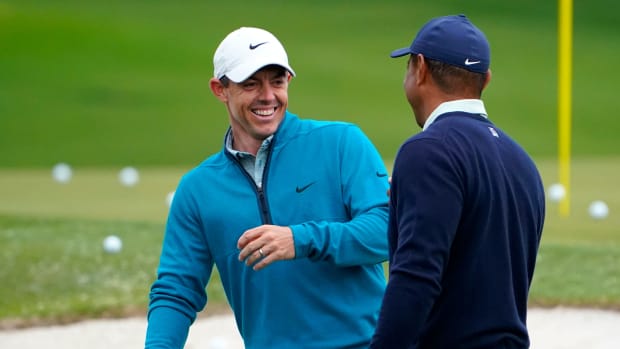 Rory McIlroy shares a laugh with Tiger Woods during a practice day prior to the 2022 Masters.