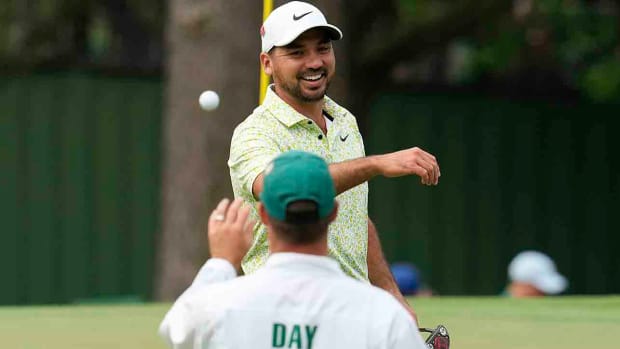Jason Day tosses his ball to his caddie during the second round of the 2023 Masters.