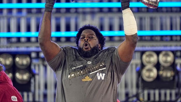 Dec 12, 2021; Hamilton, Ontario, CAN; Winnipeg Blue Bombers offensive lineman Stanley Bryant (66) hoists the Grey Cup after defeating the Hamilton Tiger-Cats in the 108th Grey Cup football game at Tim Hortons Field. Mandatory Credit: John E. Sokolowski-USA TODAY Sports  