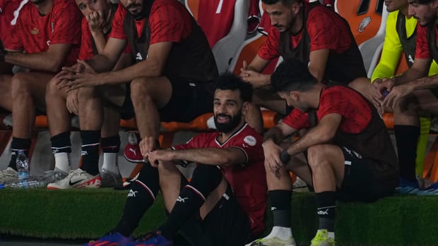 Egypt captain Mo Salah pictured (center) sat on the ground by his team's bench after being subbed off with an injury during a 2-2 draw against Ghana at the Africa Cup of Nations in January 2024