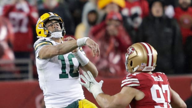 Packers quarterback Jordan Love throws a pass as 49ers defensive lineman Nick Bosa defends him.