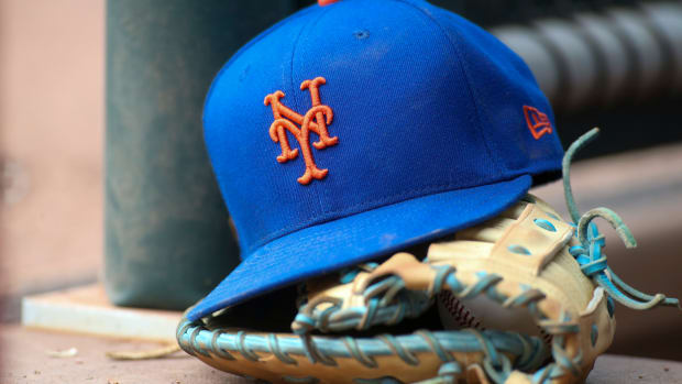 Jul 13, 2022; Atlanta, Georgia, USA; A detailed view of a New York Mets hat and glove in the dugout against the Atlanta Braves in the eighth inning at Truist Park. Mandatory Credit: Brett Davis-USA TODAY Sports