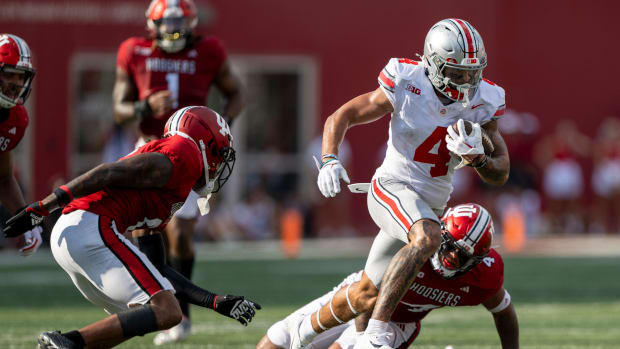 Sep 2, 2023; Bloomington, Indiana, USA; Ohio State Buckeyes wide receiver Julian Fleming (4) runs by two Indiana Hoosiers during the second half at Memorial Stadium.