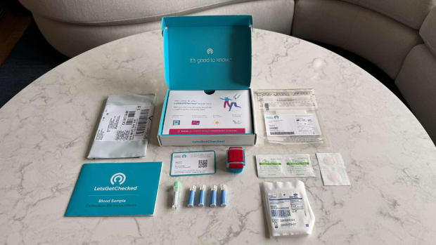 The LetsGetChecked Cholesterol Test kit components on a white and grey marble surface.