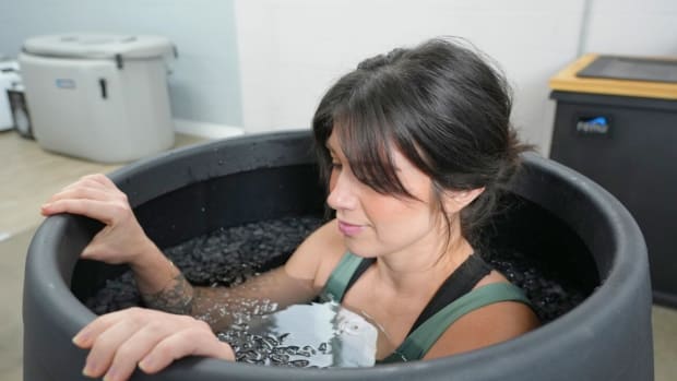 A woman tests the Ice Barrel 400 cold-plunge tub.