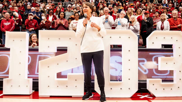 Stanford head coach Tara VanDerveer stands in front of the numbers 1203 to celebrate her become the all-time winningest coach in college basketball.