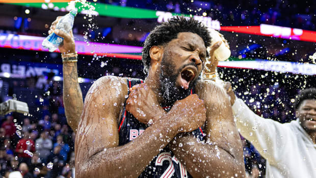 Joel Embiid is doused with water by teammates after scoring 70 points.