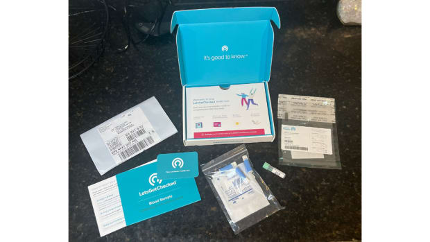 The LetsGetChecked Thyroid Test kit components on a black granite counter.