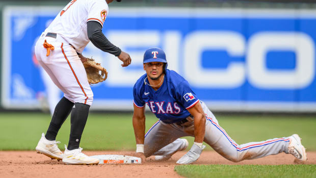 May 28, 2023; Baltimore, Maryland, USA; Texas Rangers left fielder Bubba Thompson (8) slides into second base against the Baltimore Orioles during the eighth inning at Oriole Park at Camden Yards.