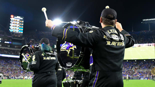 Baltimore Ravens marching band run on the field during a game