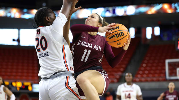 Nov 26, 2023; Auburn, Alabama, USA; Alabama A&M Lady Bulldogs guard Amiah Simmons (11) goes for a shot and is fouled by Auburn Tigers center Oyindamola Akinbolawa (20) during the first period at Neville Arena. Mandatory Credit: John Reed-USA TODAY Sports