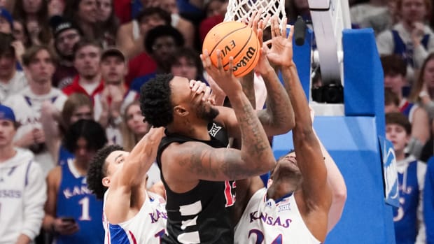 Jan 22, 2024; Lawrence, Kansas, USA; Cincinnati Bearcats forward Jamille Reynolds (13) shoots and is fouled by Kansas Jayhawks guard Kevin McCullar Jr. (15) during the second half at Allen Fieldhouse. Mandatory Credit: Denny Medley-USA TODAY Sports