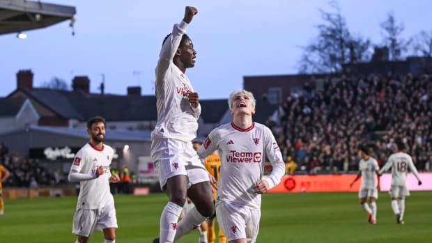 Kobbie Mainoo pictured jumping and punching the air after scoring the first goal of his Manchester United career in a 4-2 win at Newport County in January 2024