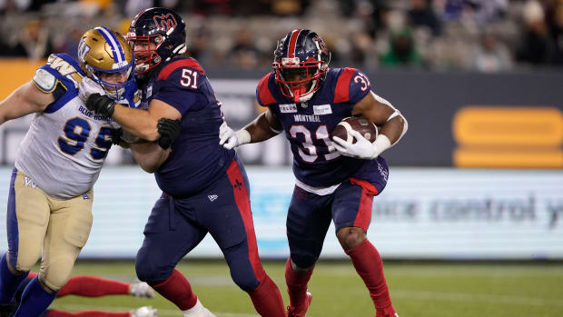 Nov 19, 2023; Hamilton, Ontario, CAN; Montreal Alouettes running back William Stanback (31) runs behind the block of offensive lineman Kristian Matte (51) on Winnipeg Blue Bombers defensive lineman Jake Thomas (95) during the 110th Grey Cup at Tim Hortons Field. Mandatory Credit: John E. Sokolowski-USA TODAY Sports  