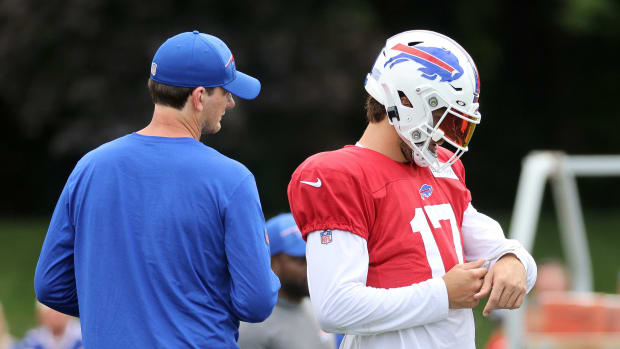 Bills quarterback Josh Allen checks the plays on his wristband with offensive coordinator Ken Dorsey.  