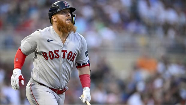 Red Sox designated hitter Justin Turner looks up after hitting a ball in the air during a game.