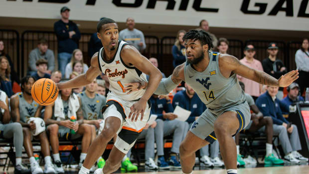 Jan 27, 2024; Stillwater, Oklahoma, USA; Oklahoma State Cowboys guard Bryce Thompson (1) drives around West Virginia Mountaineers guard Seth Wilson (14) during the first half at Gallagher-Iba Arena. 