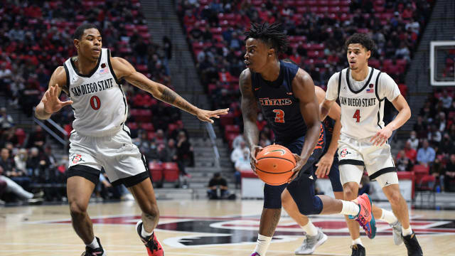 Dec 8, 2021; San Diego, California, USA; Cal State Fullerton Titans guard Latrell Wrightsell Jr. (3) goes to the basket while defended by San Diego State Aztecs forward Keshad Johnson (0) during the second half at Viejas Arena. Mandatory Credit: Orlando Ramirez-USA TODAY Sports