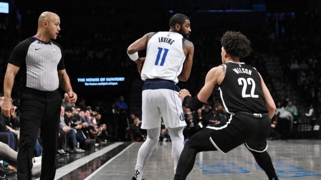 Dallas Mavericks guard Kyrie Irving (11) controls the ball while being defended by Brooklyn Nets forward Jalen Wilson (22)