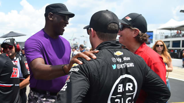 NASCAR Cup Series 23XI Racing owner Michael Jordan talks with driver Ty Dillon (42) on pit road during qualifying for the Ally 400 at Nashville Superspeedway. 