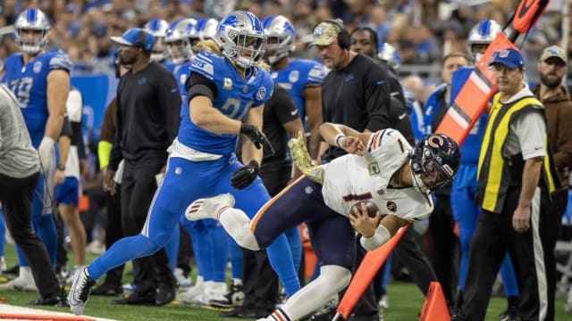 Detroit Lions linebacker Alex Anzalone pushes Chicago Bears quarterback Justin Fields out of bounds.