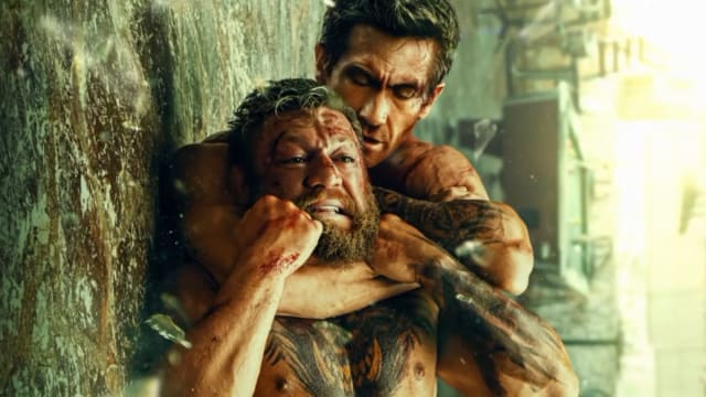 Jake Gyllenhaal locks in a rear-naked choke on Conor McGregor in a promotional image for 'Road House' (2024)