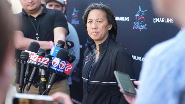 Miami Marlins general manager Kim Ng stands in front of a bunch of microphones
