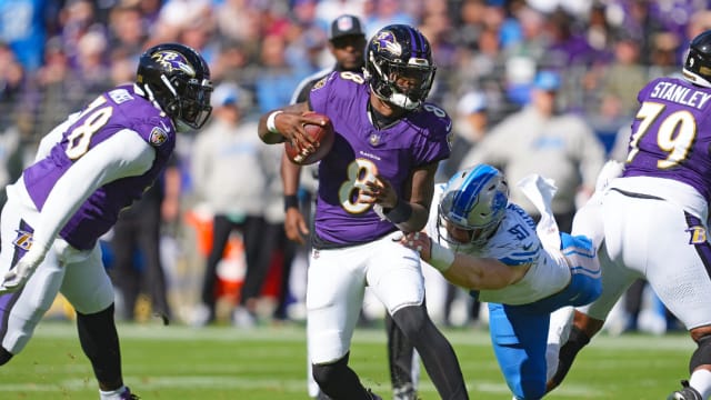 Baltimore Ravens quarterback Lamar Jackson evades Detroit Lions defensive end Aidan Hutchinson.