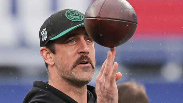 Injured Jets' QB Aaron Rodgers balances a football on one finger prior to the team's Week 8 meeting with the Giants