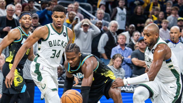 Indiana Pacers guard Bennedict Mathurin (00) dribbles the ball while Milwaukee Bucks forward Giannis Antetokounmpo (34) and forward Khris Middleton (22)
