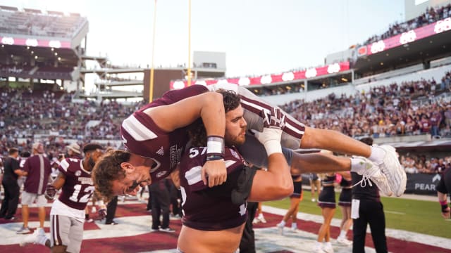 Mississippi State Bulldogs offensive lineman Cole Smith (57) carries quarterback Will Rogers (2) after the victory against Texas A&M Aggies at Davis Wade Stadium at Scott Field in 2022.