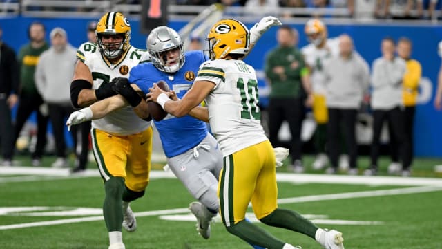 Detroit Lions rusher Aidan Hutchinson tries to tackle Green Bay Packers quarterback Jordan Love.