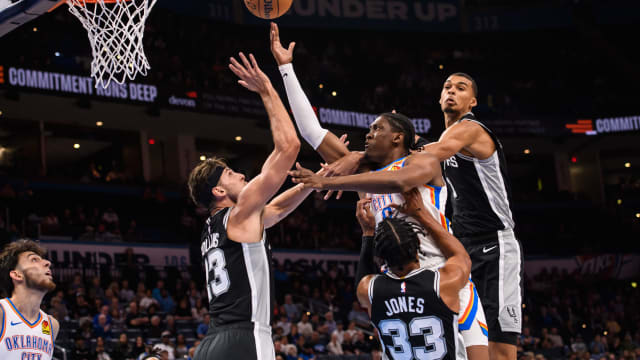 Oct 9, 2023; Oklahoma City, Oklahoma, USA; Oklahoma City Thunder forward Jalen Williams (8) shoots the ball while defended by San Antonio Spurs guard Tre Jones (33) and forward Zach Collins (23) during the first half at Paycom Center.