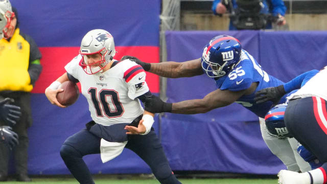 New York Giants linebacker Jihad Ward (55) has a hold on New England Patriots quarterback Mac Jones (10) in the 1st half at MetLife Stadium.