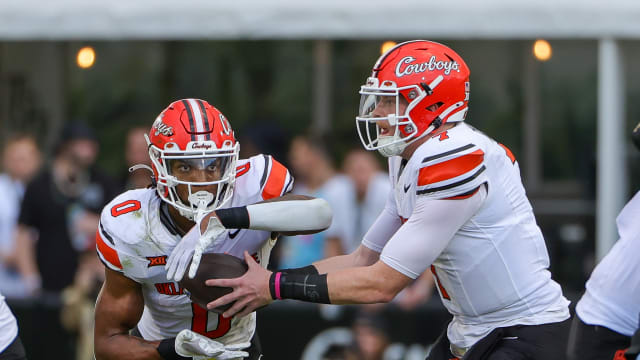 Nov 11, 2023; Orlando, Florida, USA; Oklahoma State Cowboys quarterback Alan Bowman (7) hands off to running back Ollie Gordon II (0) during the first quarter against the UCF Knights at FBC Mortgage Stadium. Mandatory Credit: Mike Watters-USA TODAY Sports 