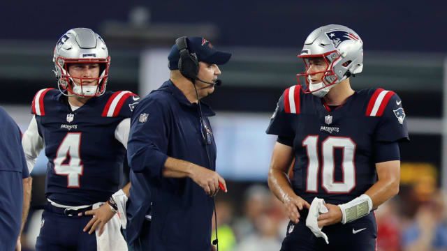New England Patriots offensive coordinator Bill O’Brien speaks with quarterback Mac Jones (10) as quarterback Bailey Zappe (4) looks on.