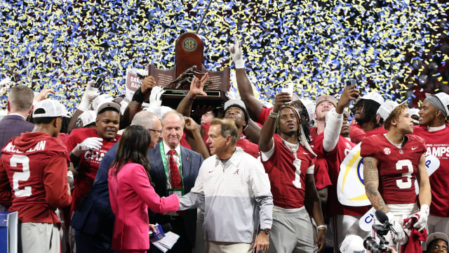 Alabama Crimson Tide head coach Nick Saban and players celebrate with the trophy on the podium after defeating the Georgia Bulldogs in the SEC championship game at Mercedes-Benz Stadium.