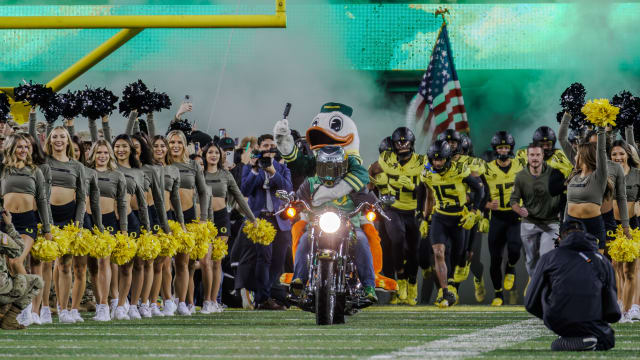 The Oregon Duck leads the football team out onto the field ahead of a matchup with the USC Trojans.
