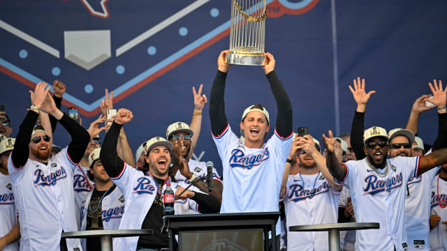 Texas Rangers shortstop Corey Seager (5) raises the trophy during the celebration outside of the ballpark after the World Series championship parade at Globe Life Field.