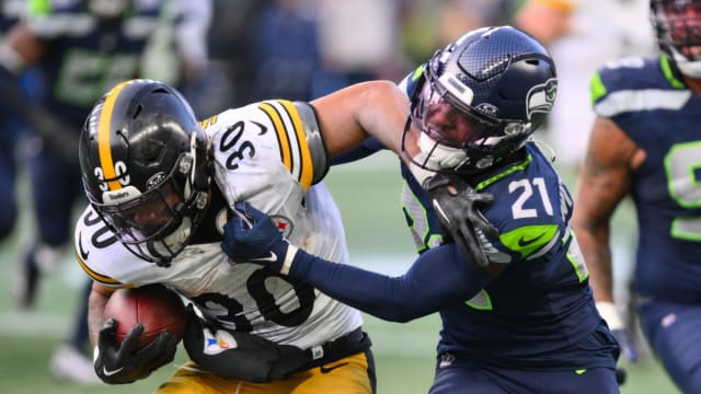 Seattle Seahawks cornerback Devon Witherspoon (21) tackles Pittsburgh Steelers running back Jaylen Warren (30) during the second half at Lumen Field.